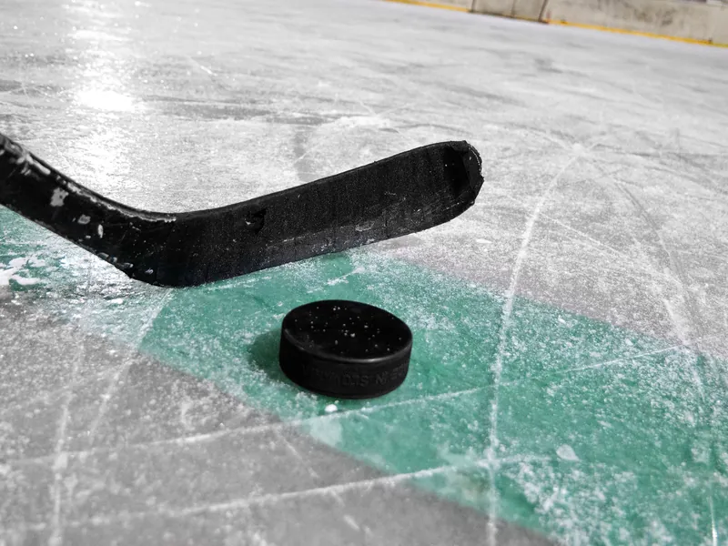 Ice hockey stick and puck on the ice